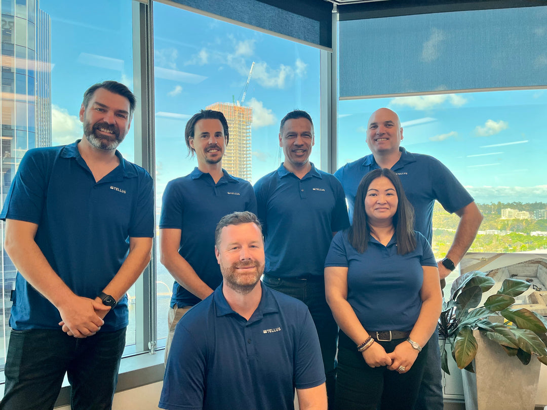 Six people in blue shirts in an office.