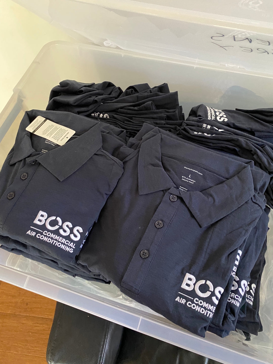 Black polo shirts with "BOSS" logo in a bin.