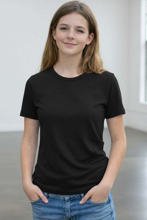 Person wearing a black t-shirt and blue jeans in a minimalistic setting