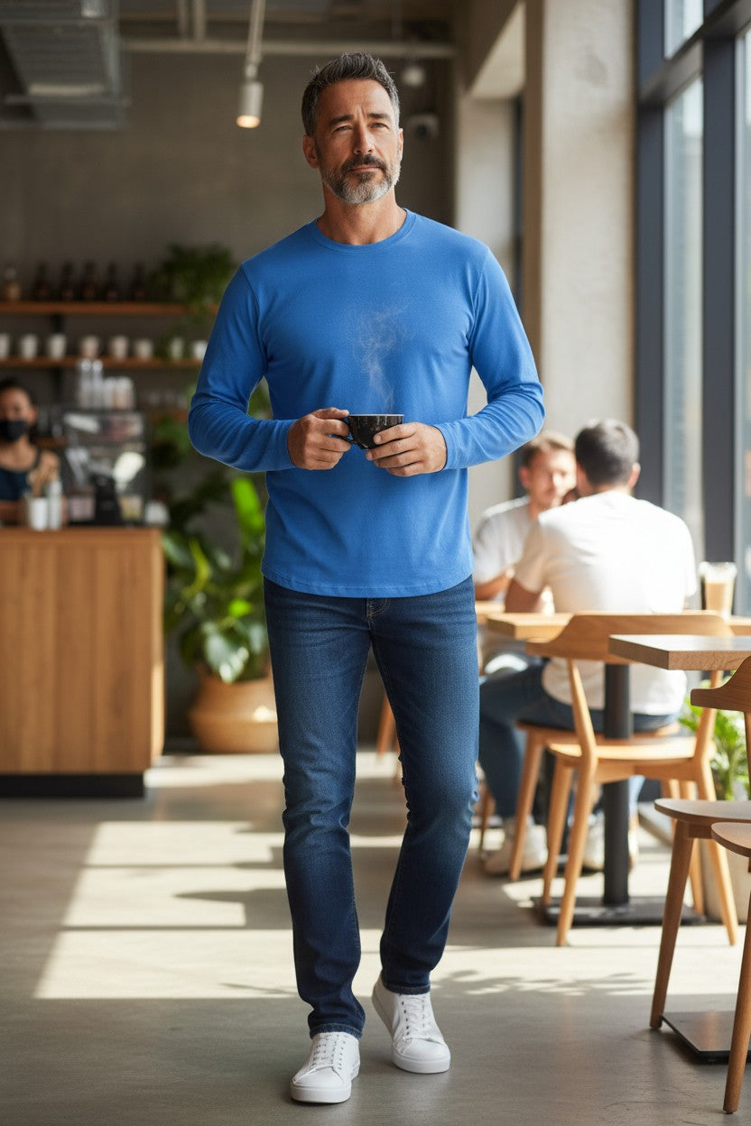 Man in a blue shirt walking in a modern cafe.