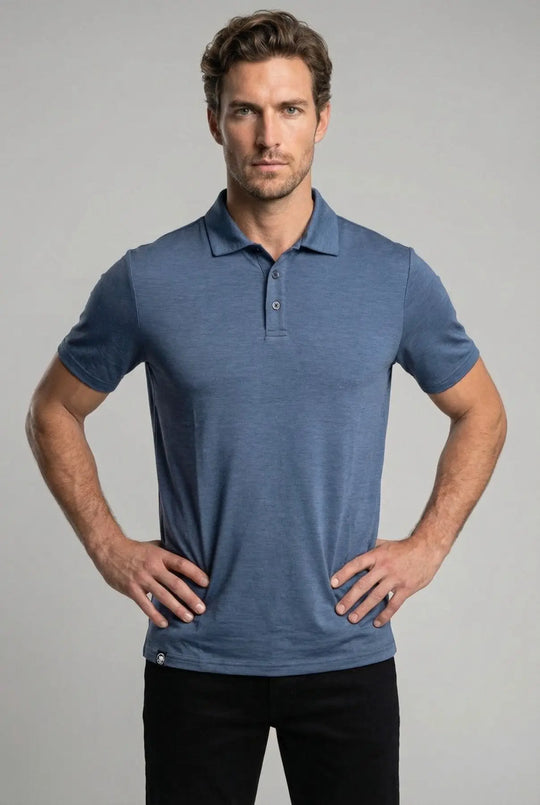 Man wearing a blue polo shirt against a gray background