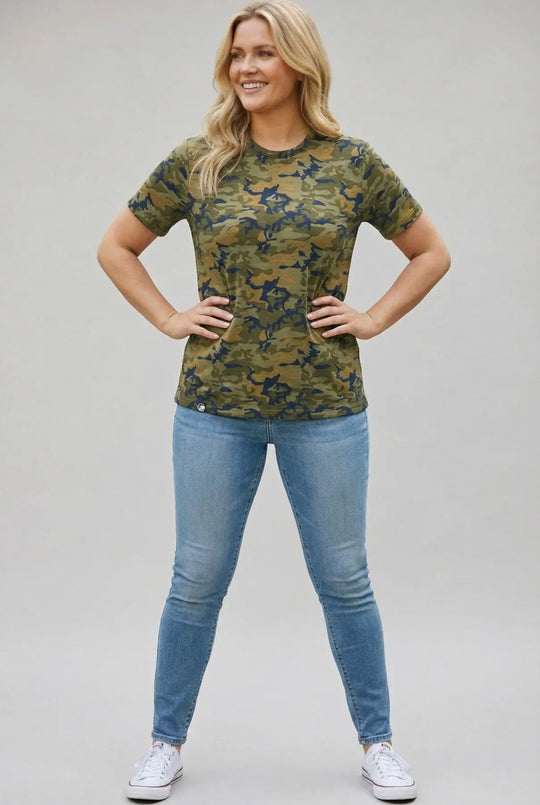 Woman wearing a camouflage t-shirt and blue jeans on a plain background