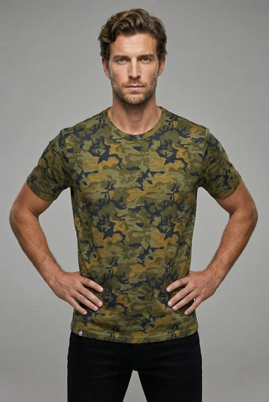 Man wearing a camouflage t-shirt against a gray background