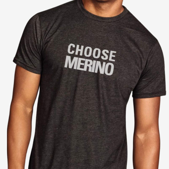 Person wearing a dark gray t-shirt with 'CHOOSE MERINO' text on a plain background
