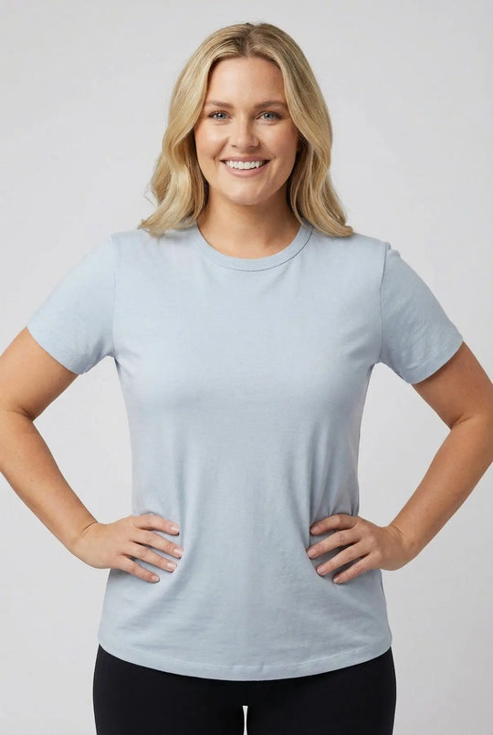 Woman wearing a light blue t-shirt against a plain background