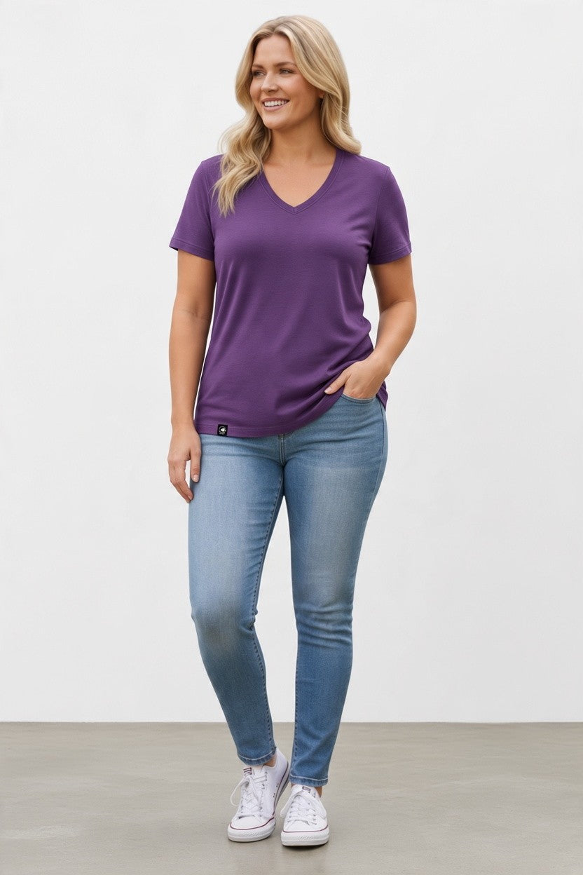 A pregnant woman wearing a purple merino wool T-shirt.