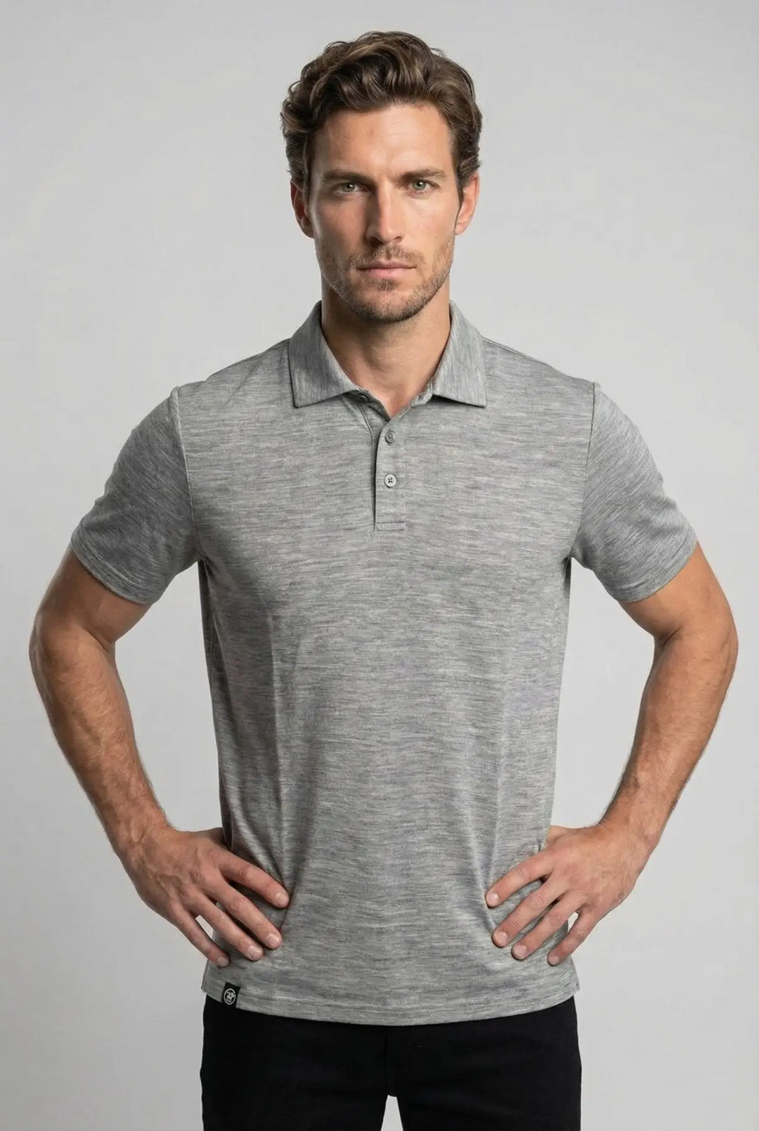 Man wearing a gray polo shirt against a light gray background