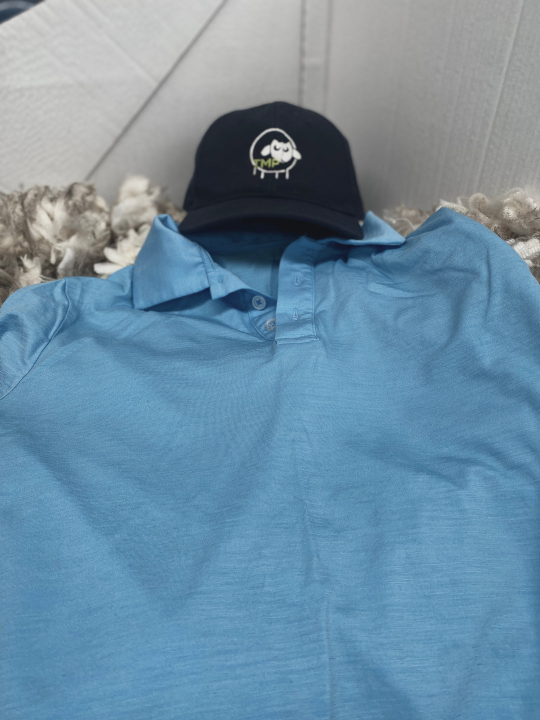 Blue shirt with a black cap on a textured surface