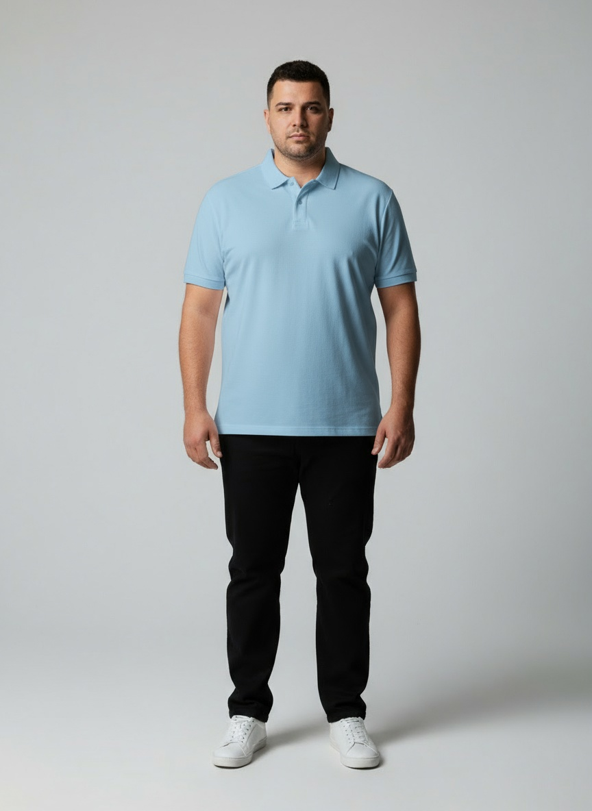 Man wearing a light blue polo shirt and black pants on a gray background
