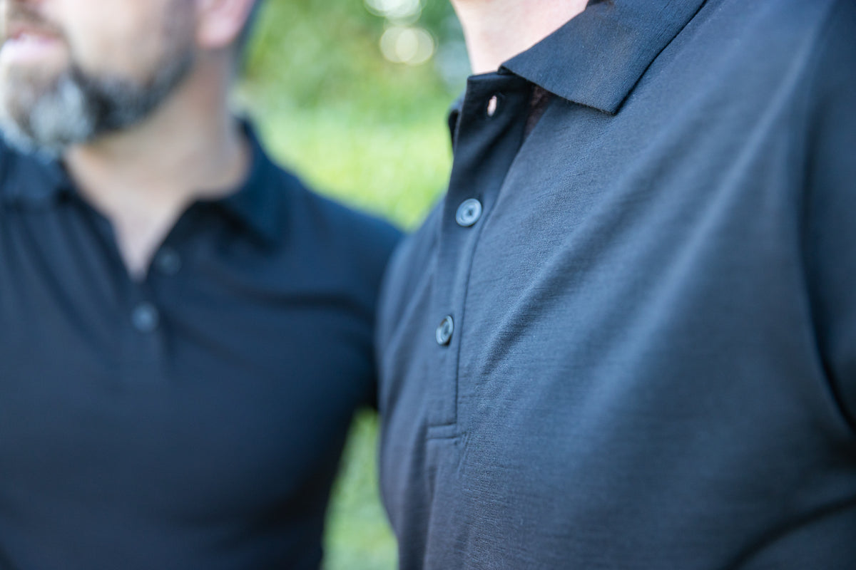 Close-up of two men in dark polo shirts.