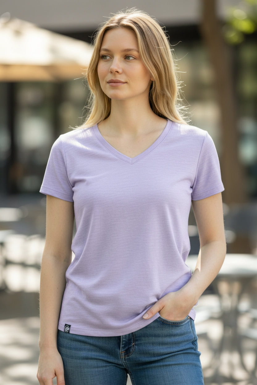 Woman wearing a light purple t-shirt and blue jeans outdoors