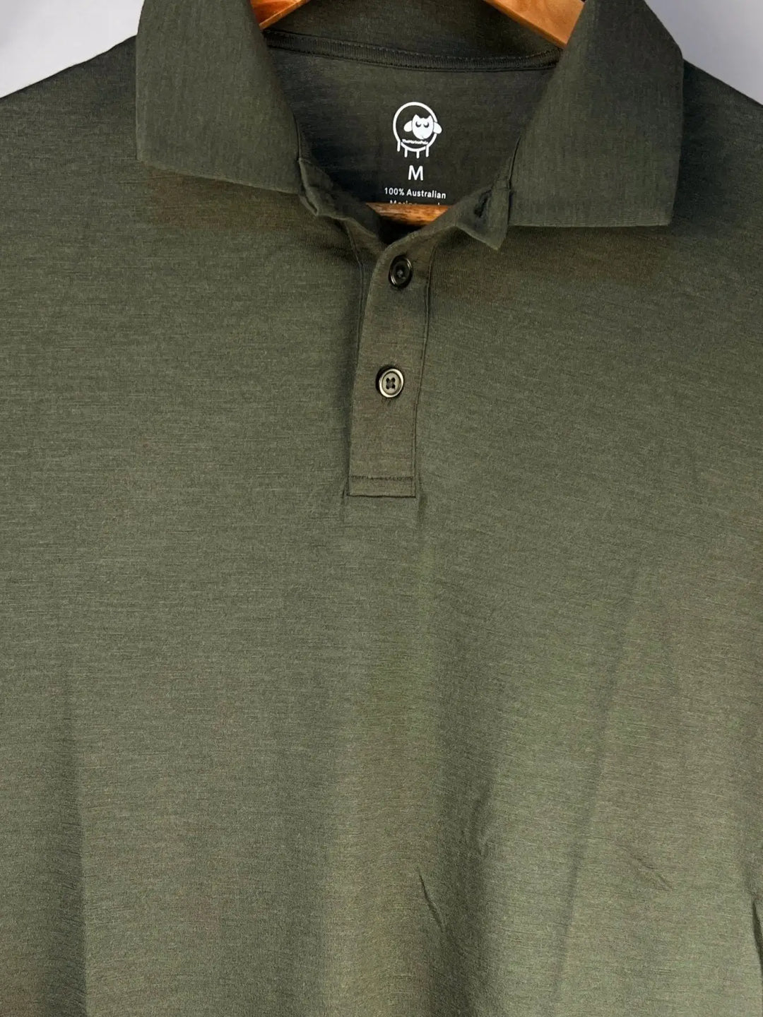 Green polo shirt with a brand logo on the collar against a white background