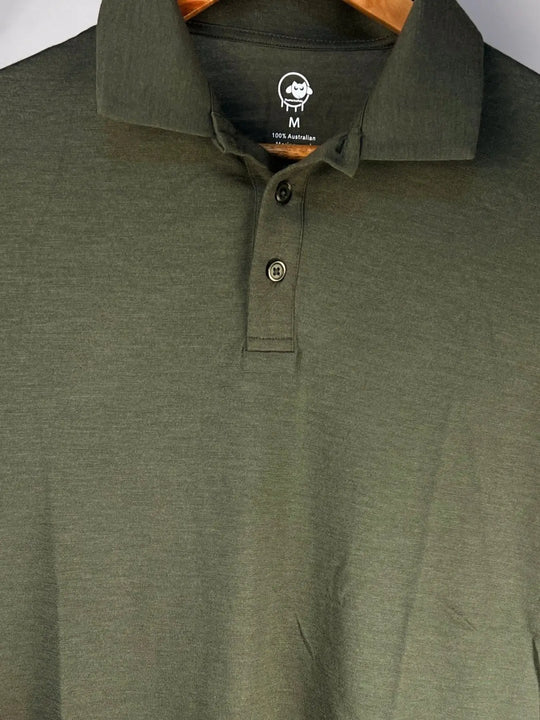 Green polo shirt with a brand logo on the collar against a white background