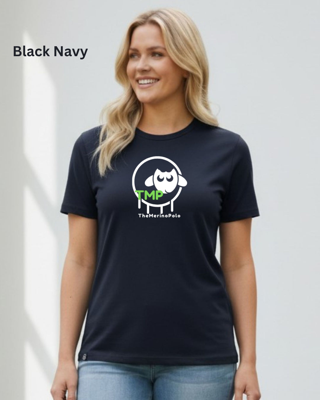 A woman wearing a navy blue t-shirt with a white sheep graphic and green &