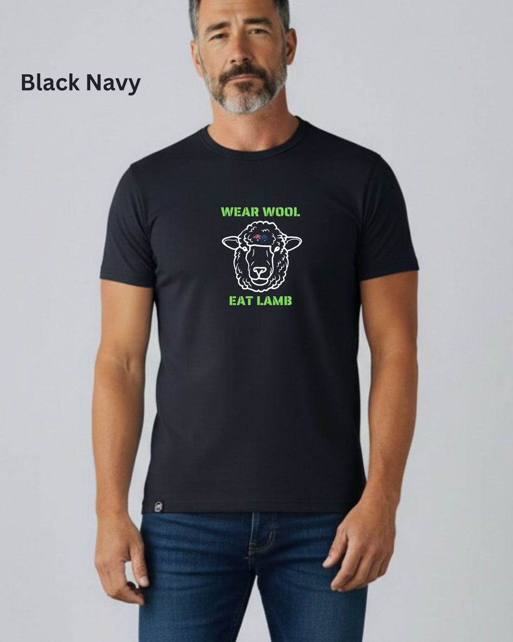 A man wearing a black short-sleeve t-shirt with a green and white graphic of a sheep and the text 'WEAR WOOL EAT LAMB'. The image has a 'Black Navy' label in the top left corner.