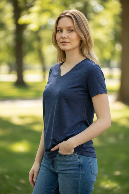 Woman wearing a blue shirt and jeans standing in a park