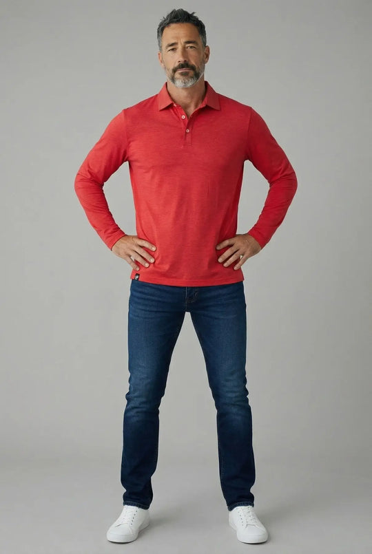 Man wearing a red long-sleeve polo shirt and blue jeans on a gray background