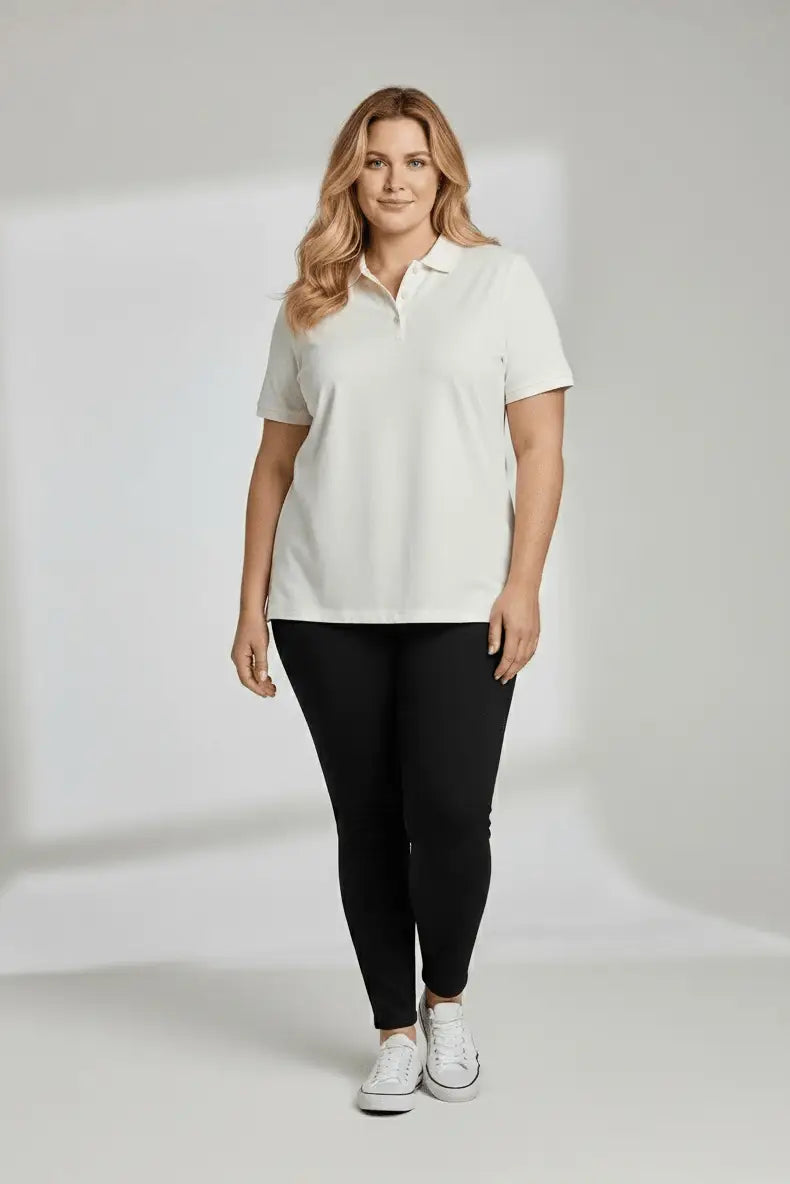 Woman wearing a white polo shirt and black leggings on a plain background