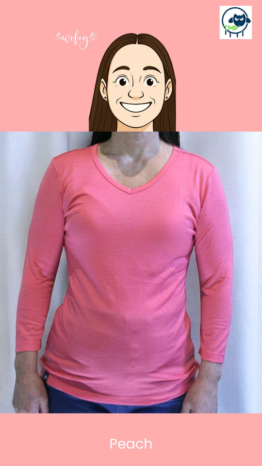 Person wearing a peach long-sleeve shirt with a plain background