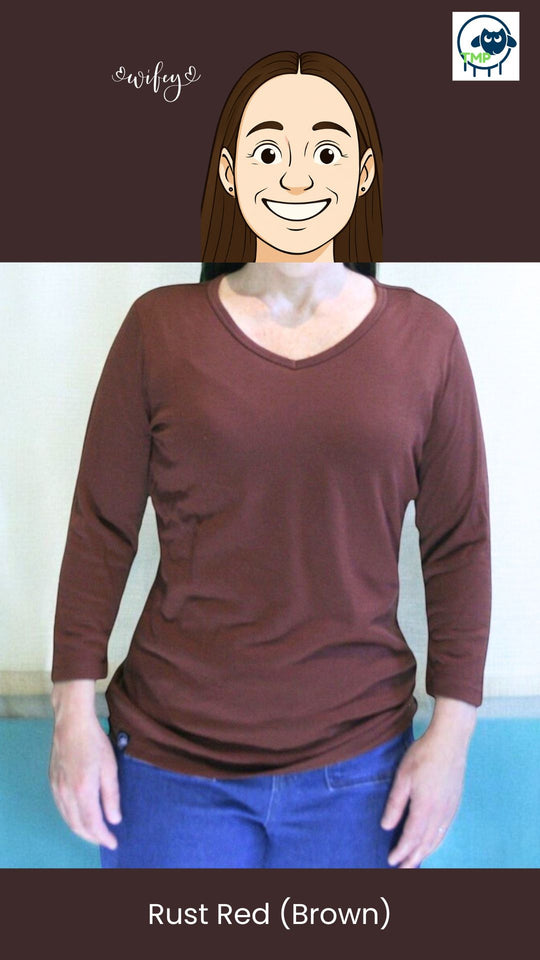 Person wearing a rust red long-sleeve shirt with a plain background