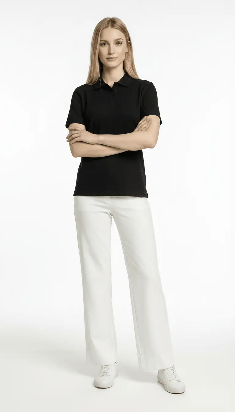 Woman wearing a black polo shirt and white pants on a white background