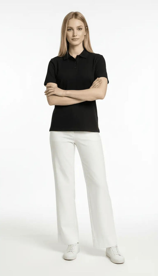 Woman wearing a black polo shirt and white pants on a white background