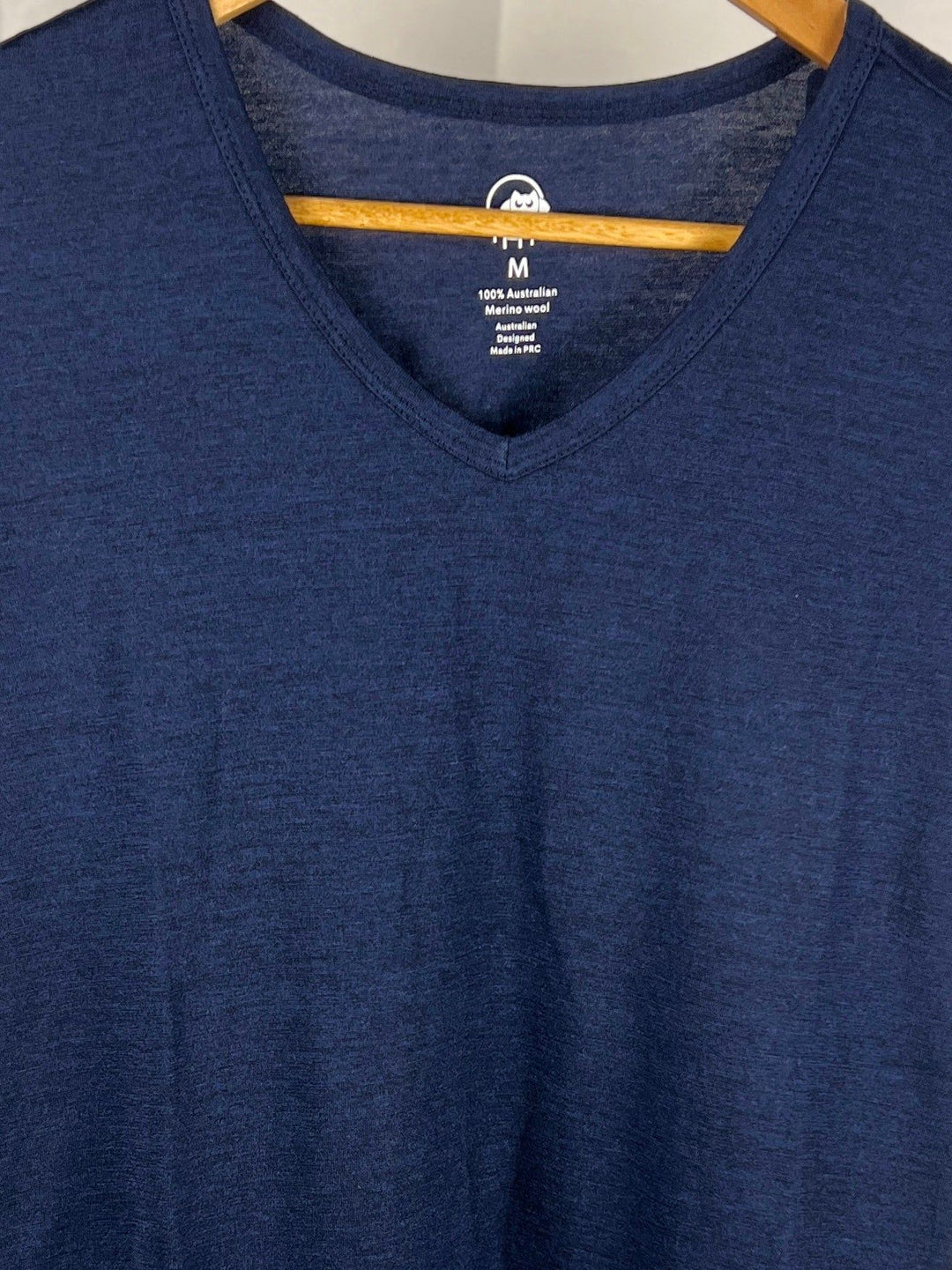 Blue V-neck t-shirt on a hanger with brand label visible