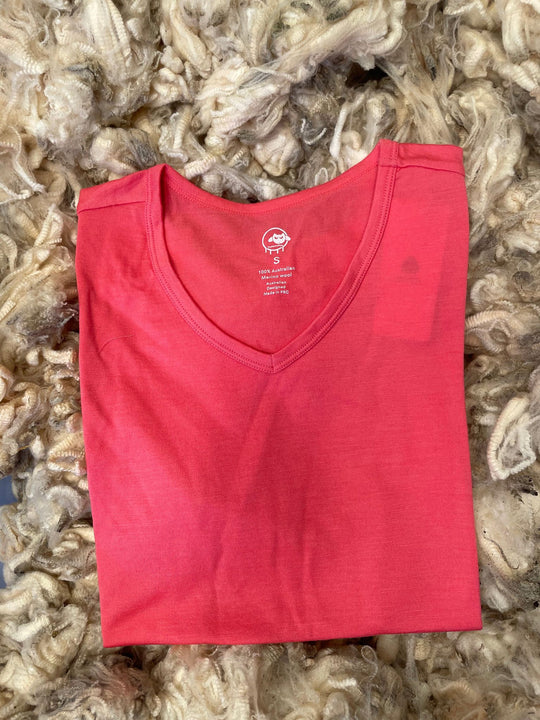 Folded red shirt on a bed of raw wool fibers