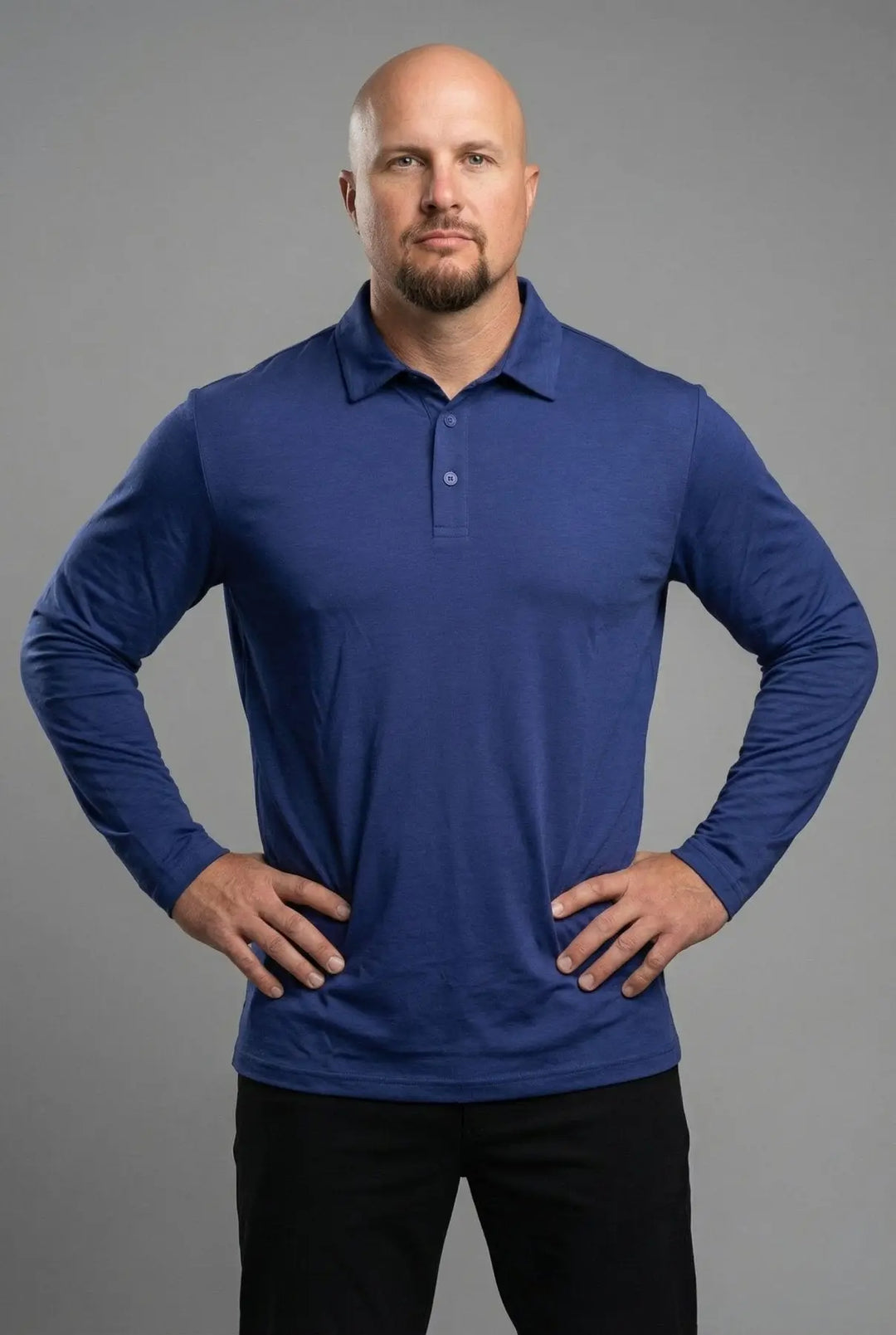 Man wearing a blue long-sleeve polo shirt against a gray background