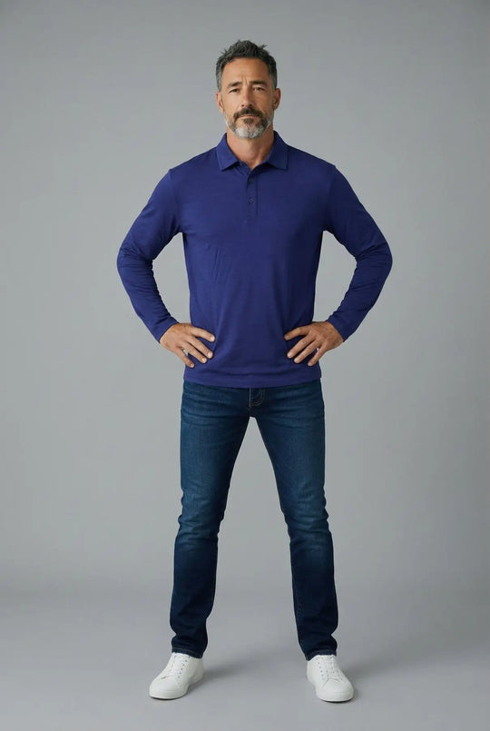 Man wearing a blue long-sleeve polo shirt and jeans on a gray background